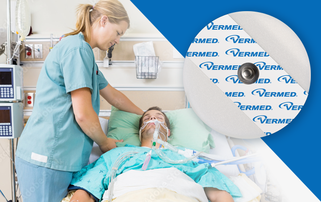 Caregiver assisting a patient in a hospital bed with monitoring leads; round Vermed ECG electrode close-up.